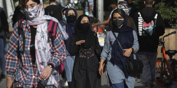 People wear protective face masks to help prevent the spread of the coronavirus in downtown Tehran, Iran, Monday, April 5, 2021. Iran's capital is once again under a  code red status, the highest level of restrictions imposed to curb the spread of the coronavirus as the country struggles with a new surge in daily deaths. (AP Photo/Vahid Salemi)